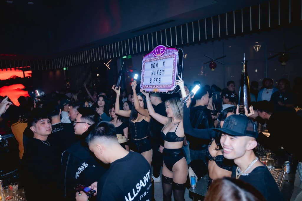 Crowded nightclub floor with bottle service and ambient lighting
