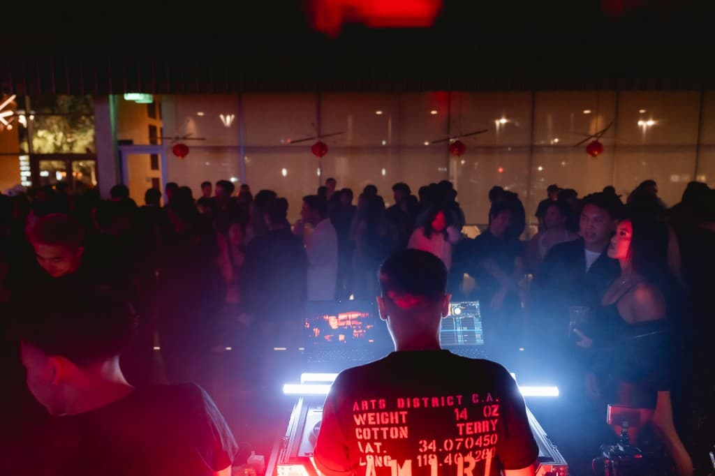 DJ performing while the crowd fills the room